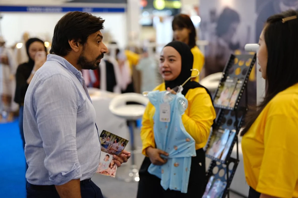 Staf Lemone menunjukkan produk kepada pembeli di pameran